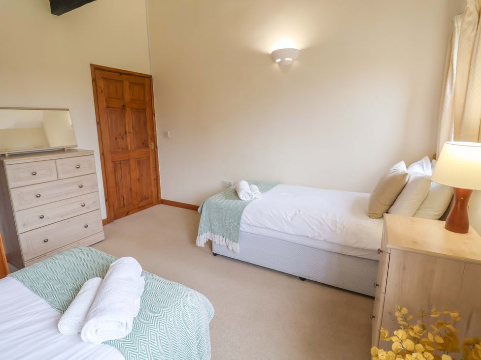 A bedroom with single beds and a dresser at Beechwood in Wood Norton