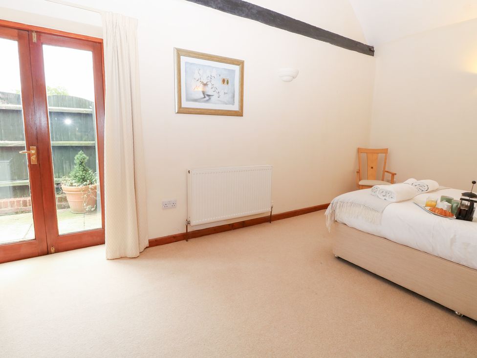 A bedroom with a bed and bedside table at Willow in Wood Norton near Foulsham