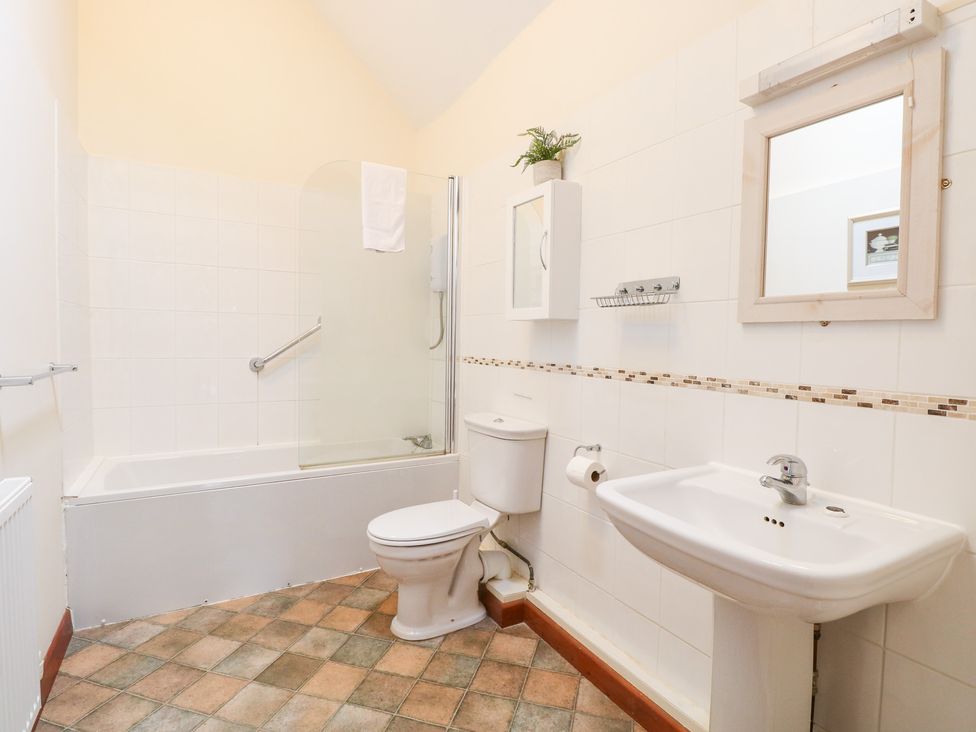 A bathroom with a bathtub, toilet, and sink at Willow in Wood Norton near Foulsham