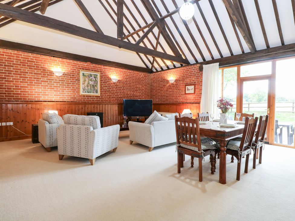 A living room with a sofa and dining table at Pear Tree in Wood Norton