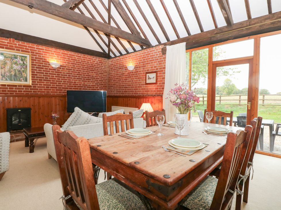 A dining room with a table and chairs at Pear Tree in Wood Norton