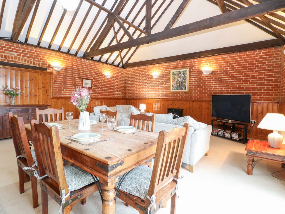 A dining room with a table and chairs at Pear Tree in Wood Norton