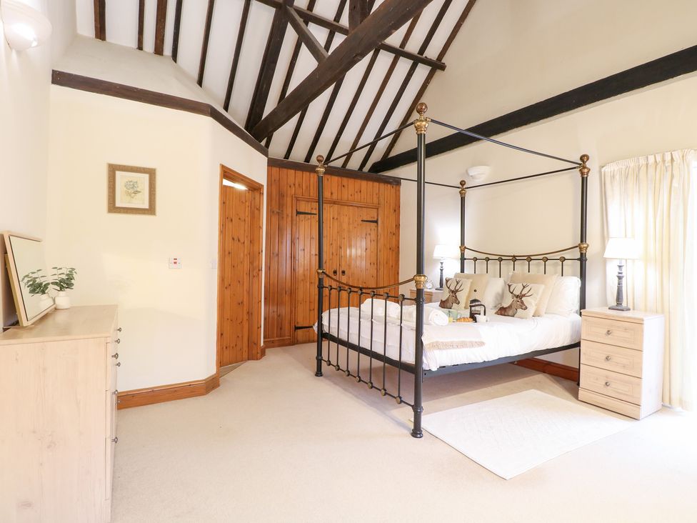 A bedroom with a four-poster bed and a dresser at Pear Tree in Wood Norton