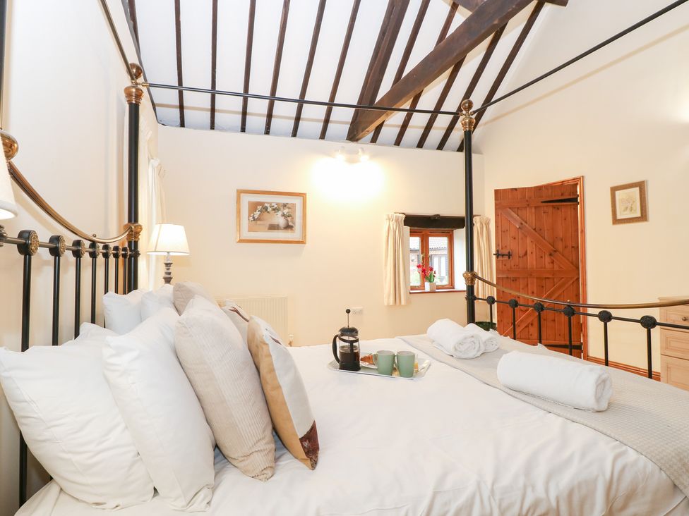A bedroom with a bed and a tea set at Pear Tree in Wood Norton