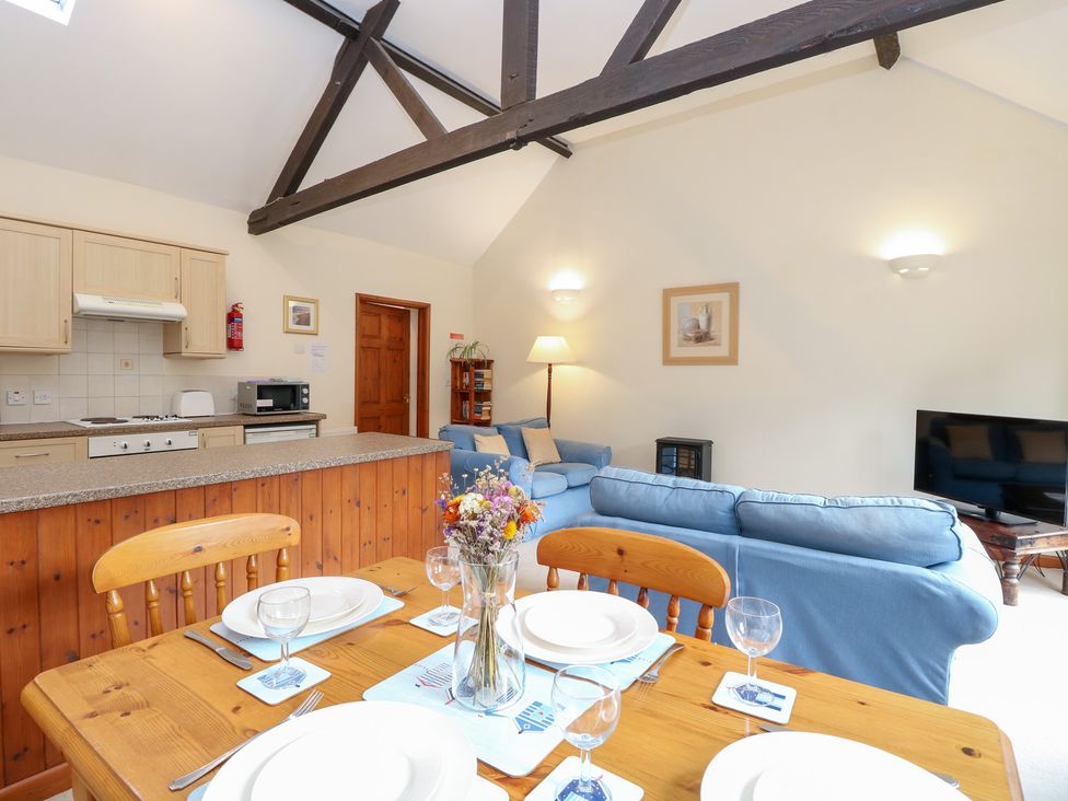 A living room with a dining table and kitchen area at Holly Berry Wood Norton near Foulsham