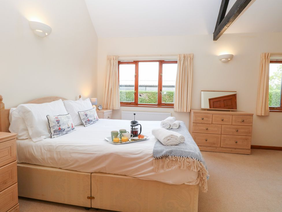 A bedroom with a bed and dresser at Holly Berry in Wood Norton near Foulsham