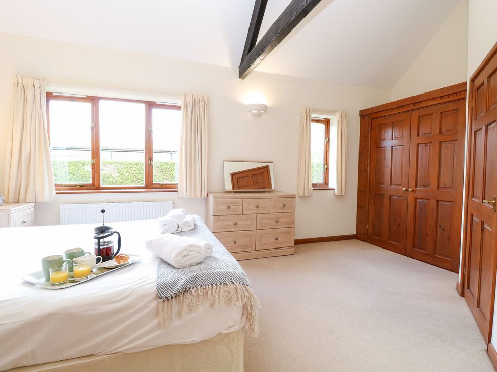 A bedroom featuring a bed with a dining tray on it at Holly Berry in Wood Norton near Foulsham