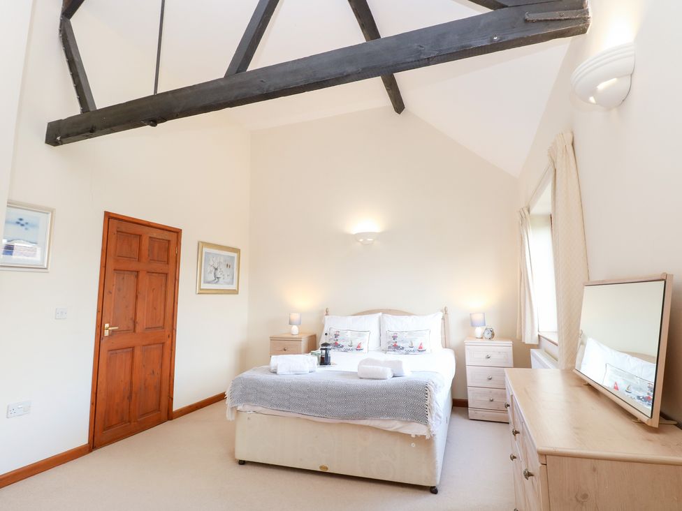 A bedroom with a bed and bedside tables at Holly Berry Wood Norton near Foulsham