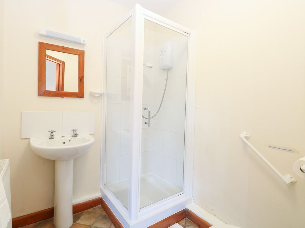A bathroom with a shower, sink, and mirror at Holly Berry in Wood Norton near Foulsham
