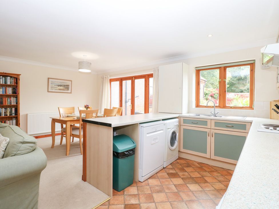 A kitchen with a dining area and a washing machine at Sycamore in Wood Norton near Foulsham