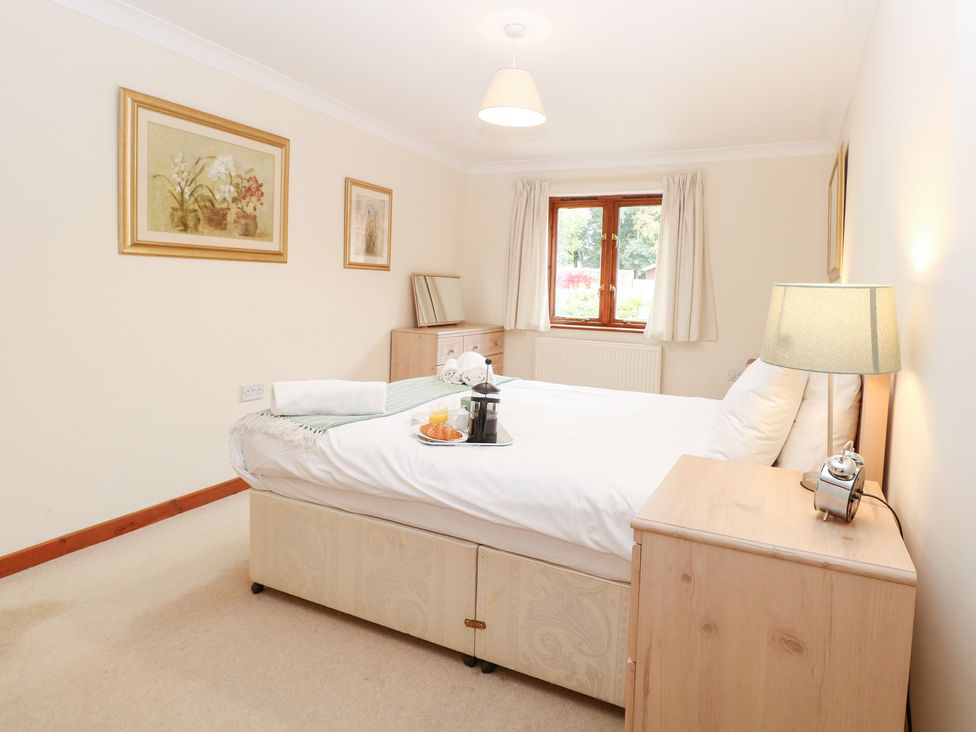 A bedroom with a bed and nightstand at Sycamore in Wood Norton near Foulsham