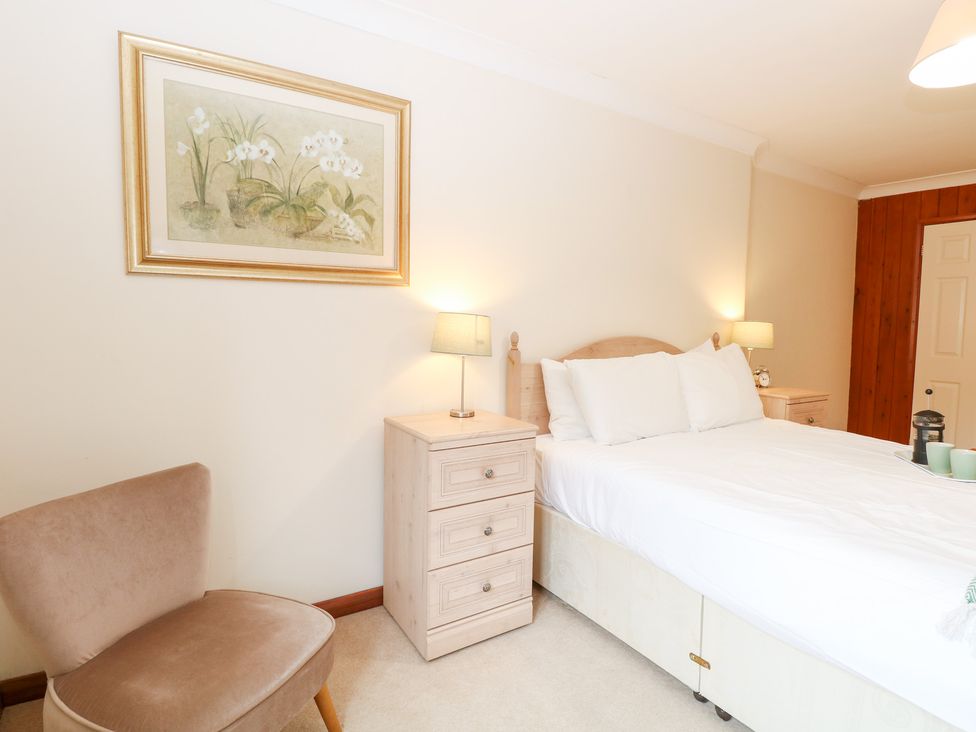 A bedroom with a bed and nightstand at Sycamore in Wood Norton near Foulsham