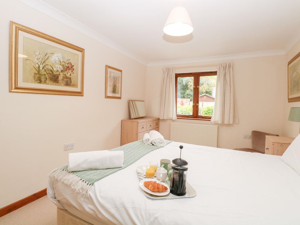 A bedroom with a breakfast tray on the bed at Sycamore in Wood Norton near Foulsham