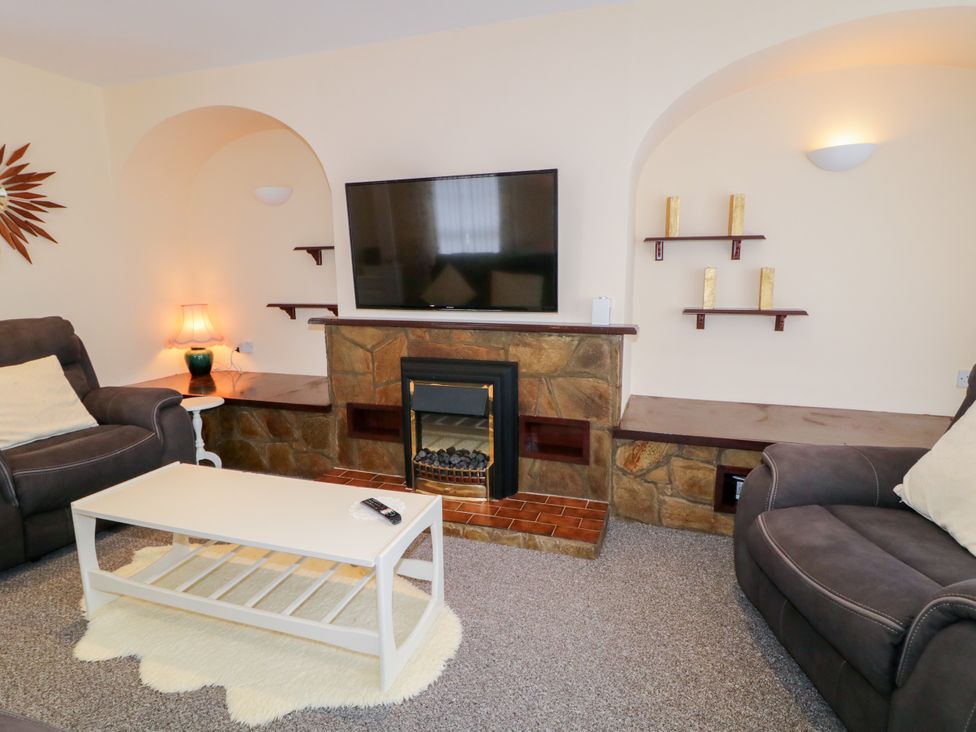 A living room with a fireplace and television at 3 Warke Place Castlerock