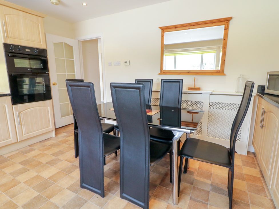 A dining room with a table and chairs at 3 Warke Place Castlerock