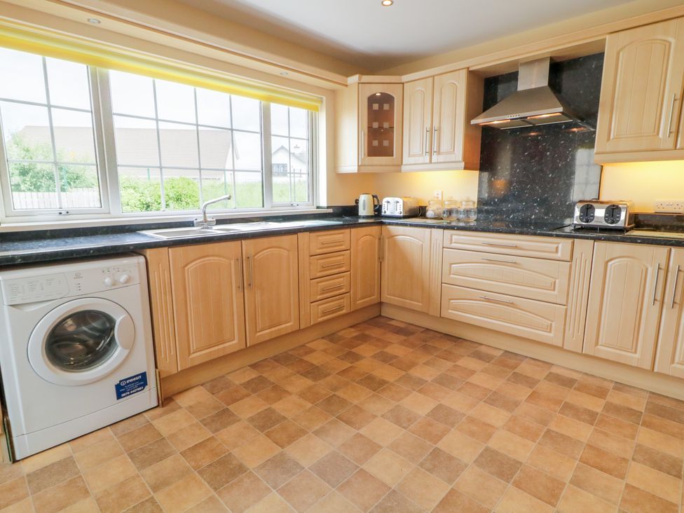 A kitchen with a washing machine and countertop at 3 Warke Place in Castlerock