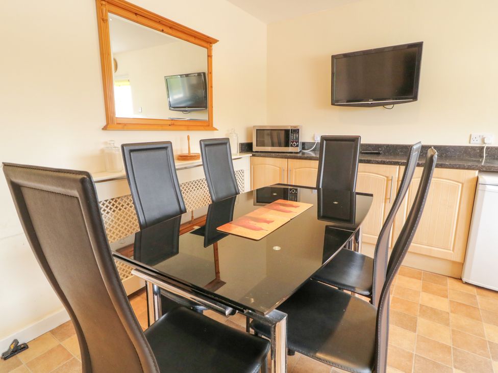 A dining room with a table and chairs at 3 Warke Place in Castlerock