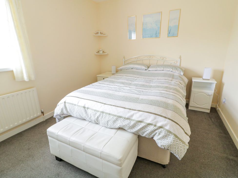 A bedroom with a bed and bedside tables at 3 Warke Place in Castlerock