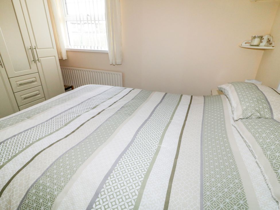 A bedroom with a bed and wardrobe at 3 Warke Place Castlerock