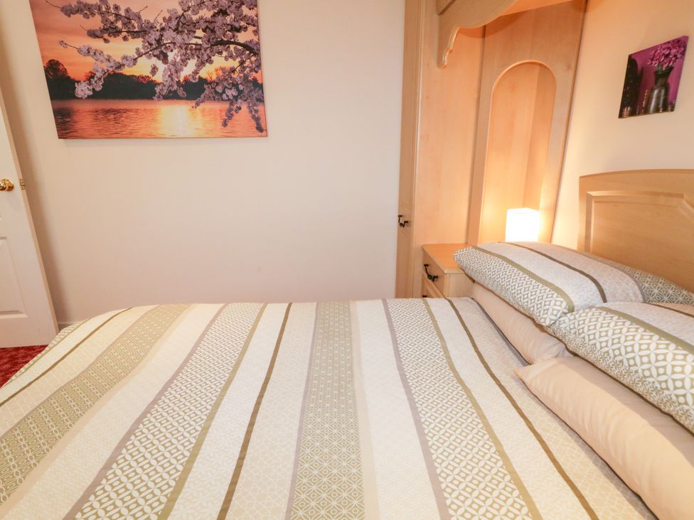A bedroom with a bed and decorative paintings at 3 Warke Place Castlerock