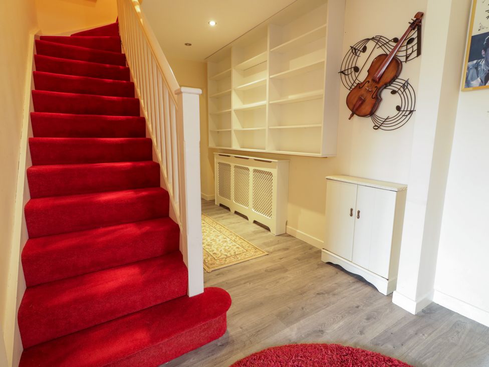 A hallway with stairs and shelves at 3 Warke Place Castlerock