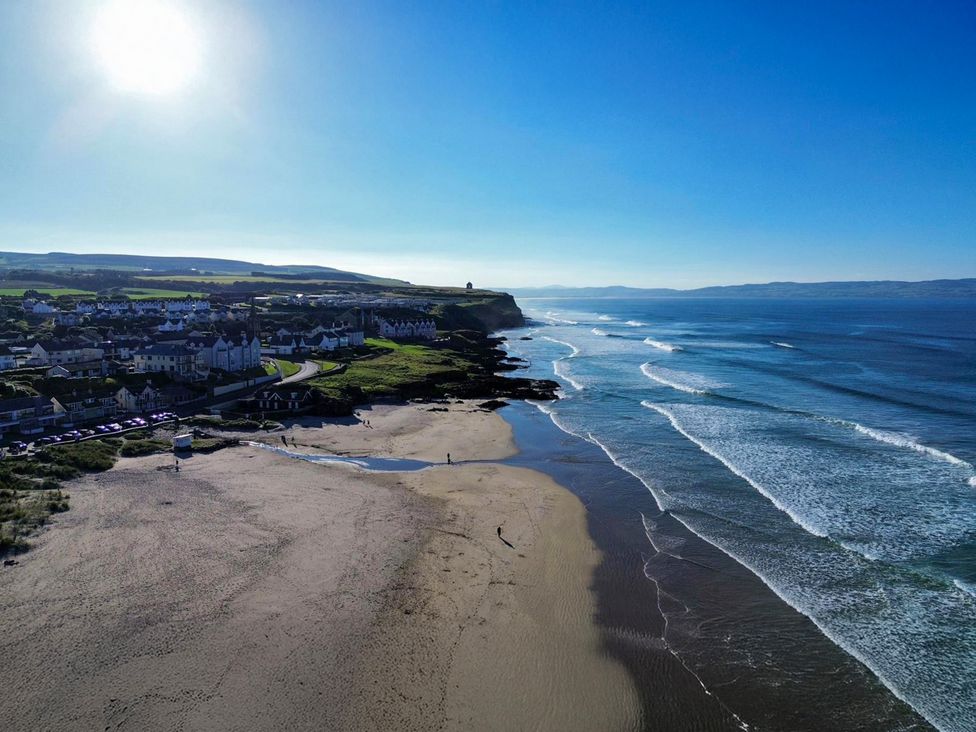 A beach with waves and houses nearby at 3 Warke Place in Castlerock