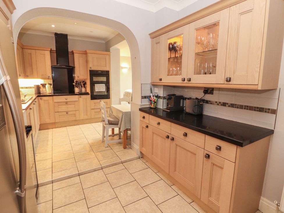 A kitchen with wooden cabinets and appliances at High Cross in Keswick