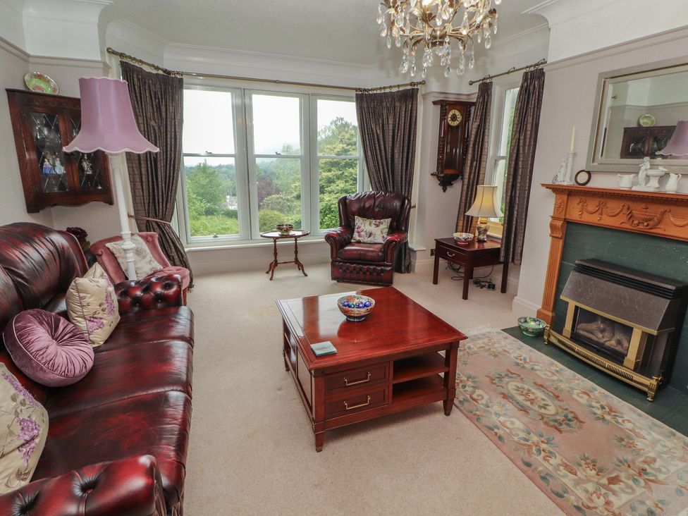 A living room with a sofa, armchair, and coffee table at High Cross in Keswick