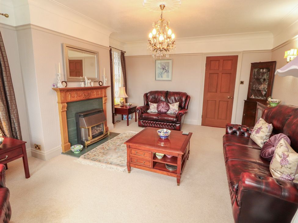 A living room with a fireplace and seating area at High Cross in Keswick