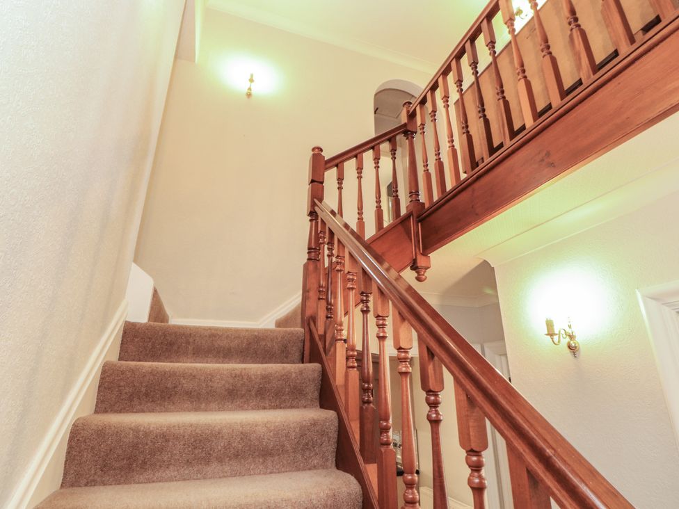 A staircase with wooden handrail and carpet at High Cross in Keswick