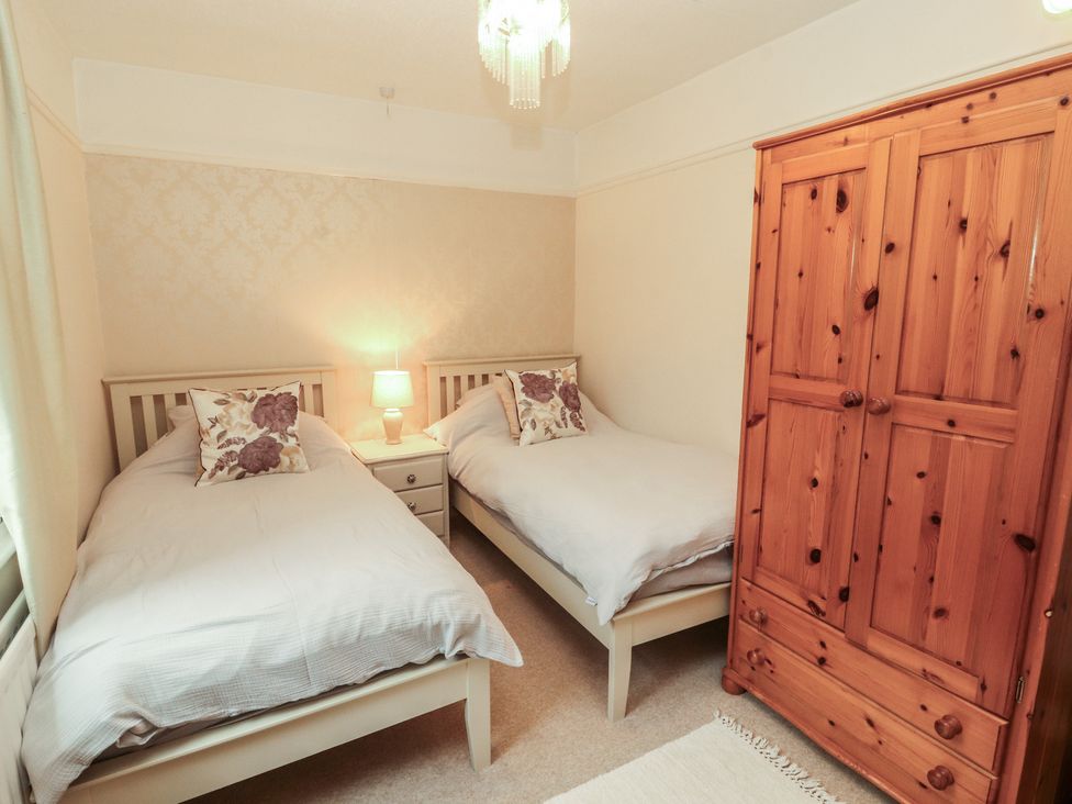 A bedroom with two beds and a wardrobe at High Cross in Keswick
