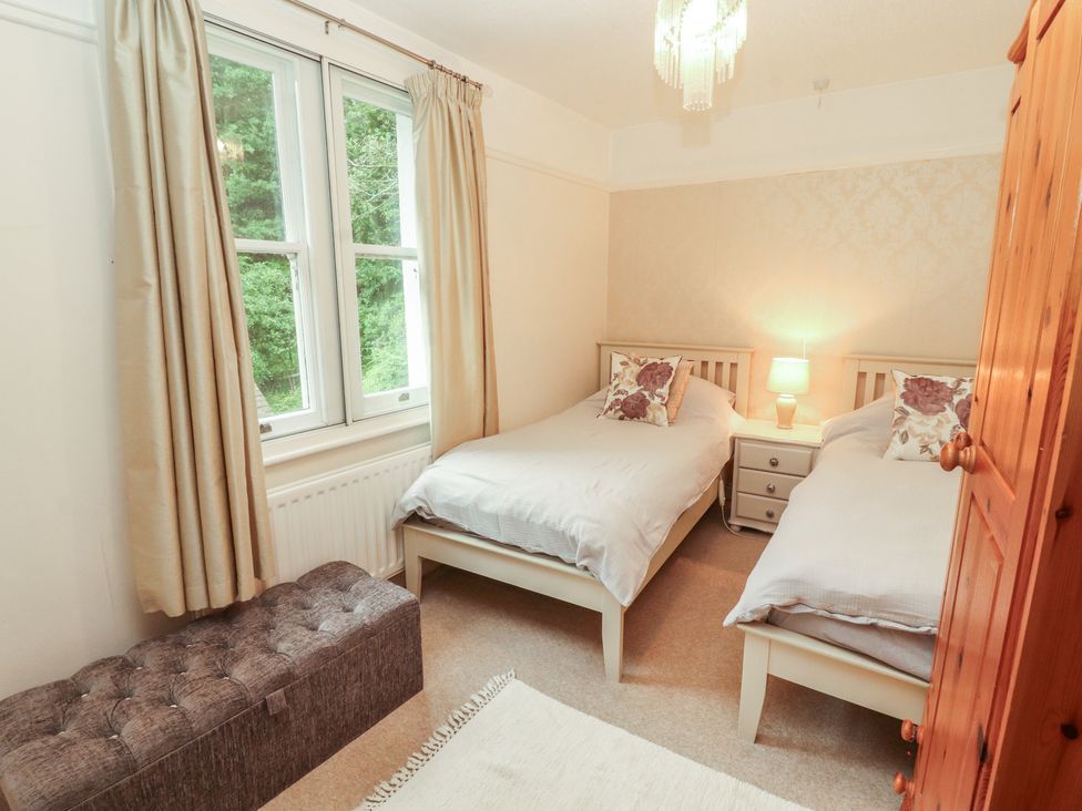 A bedroom with two beds and a lamp on a bedside table at High Cross in Keswick