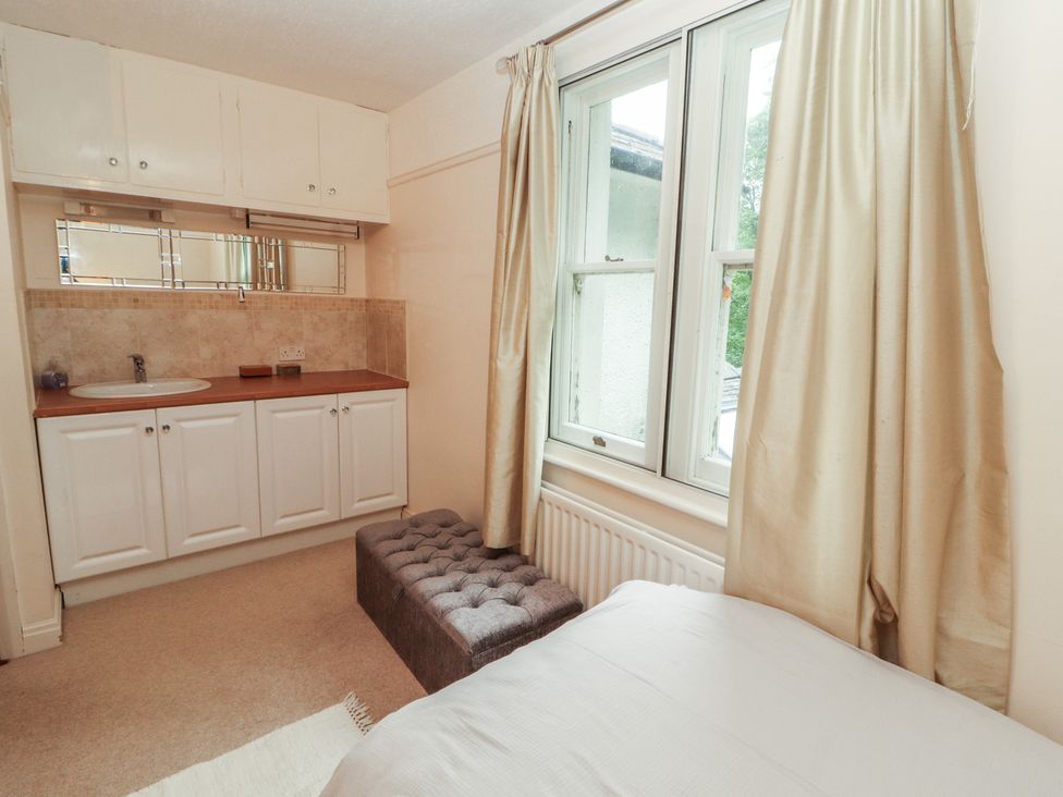 A bedroom with a bed, window and vanity at High Cross in Keswick