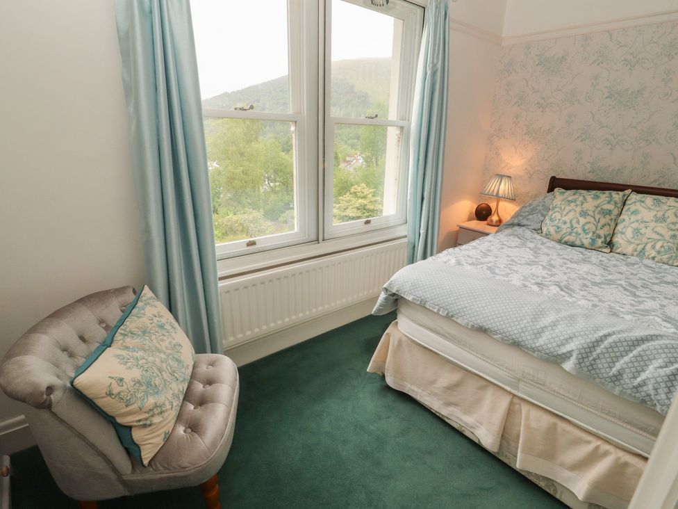 A bedroom with a bed and windows at High Cross in Keswick
