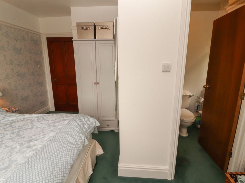 A bedroom with a bed and wardrobe at High Cross in Keswick