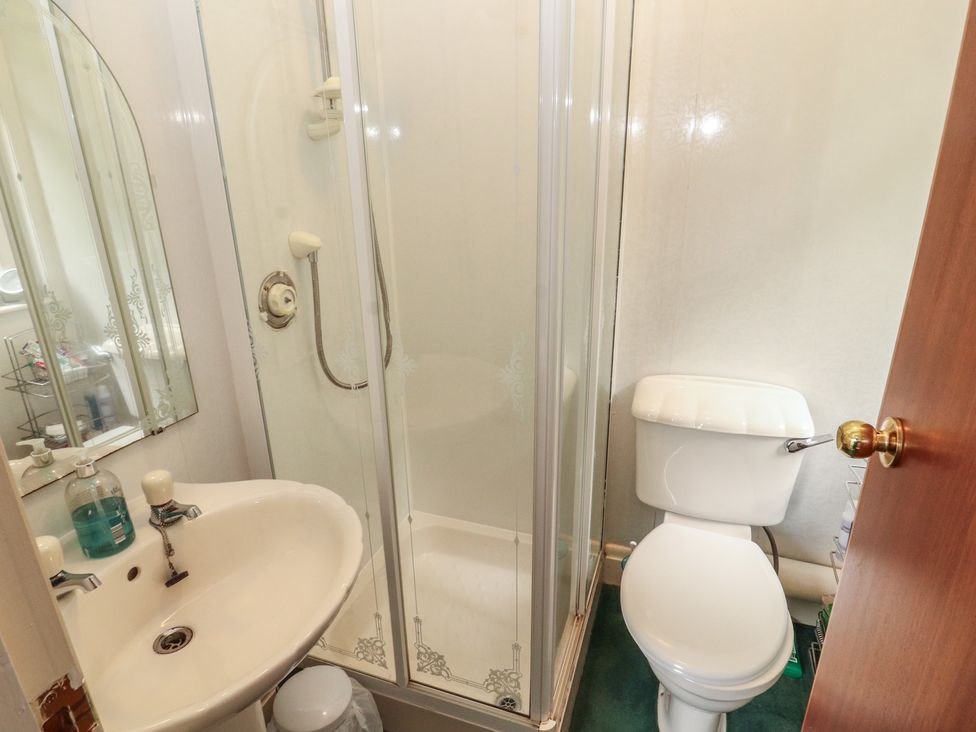 A bathroom with a shower, toilet, and sink at High Cross in Keswick