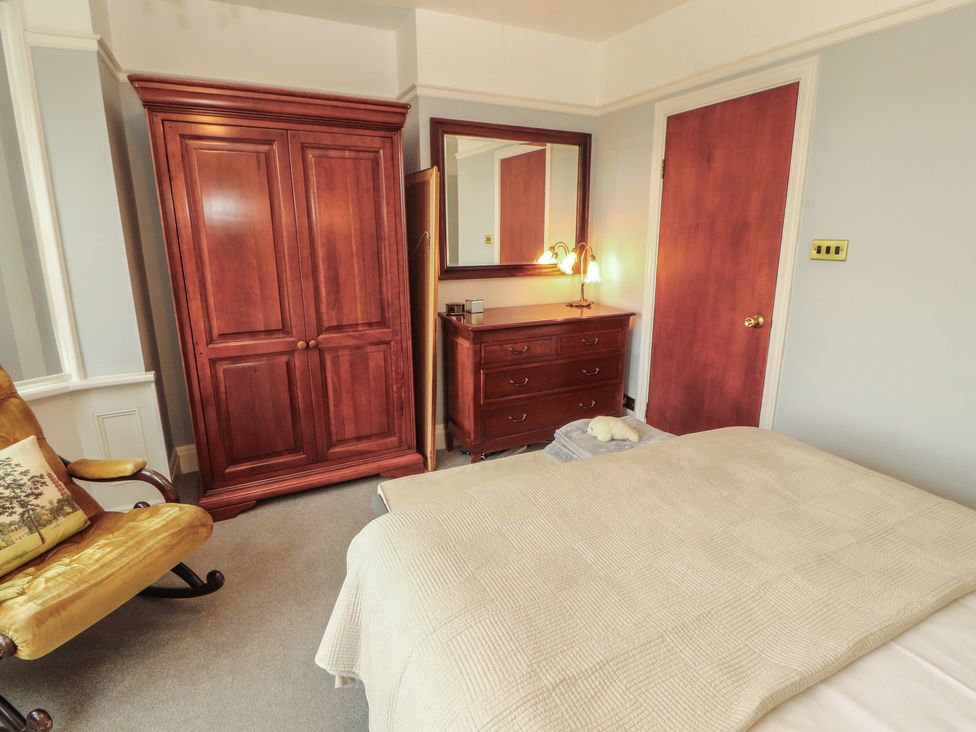 A bedroom with a bed and wooden furniture at High Cross in Keswick