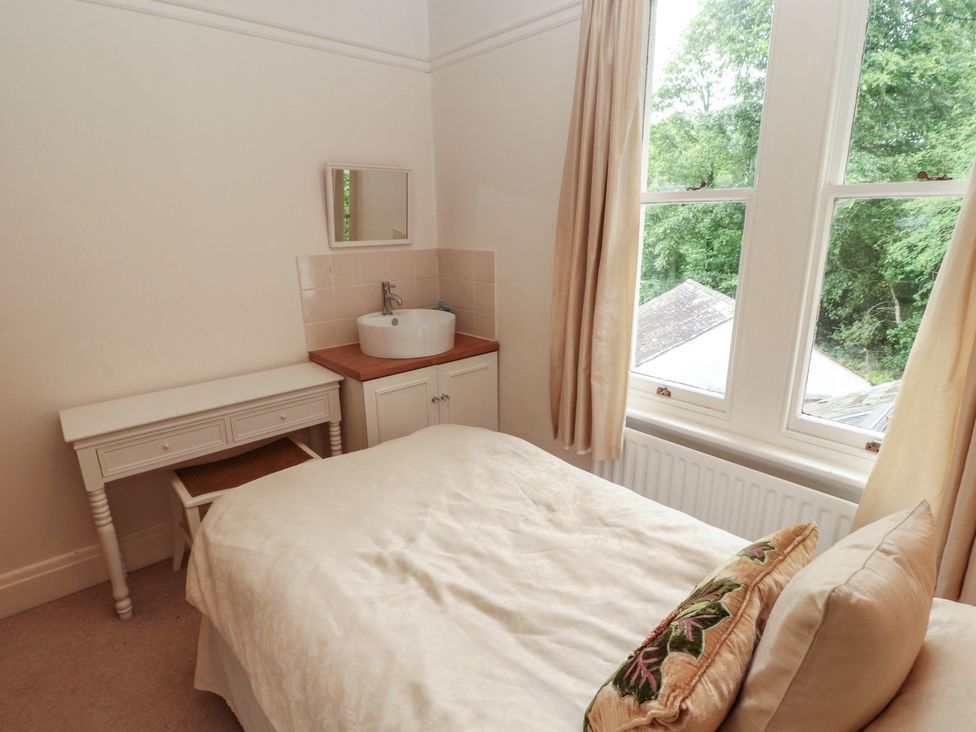 A bedroom with a bed and wash basin at High Cross in Keswick