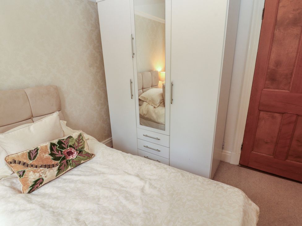 A bedroom with a bed and wardrobe at High Cross in Keswick