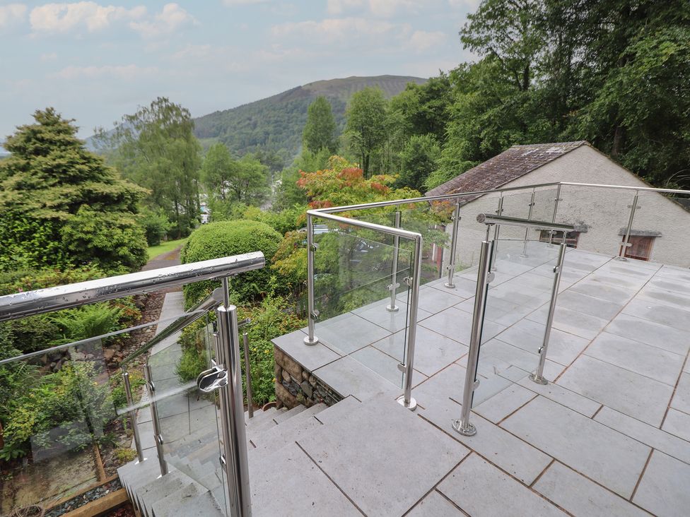 A patio with steps and railing overlooking a garden at High Cross in Keswick