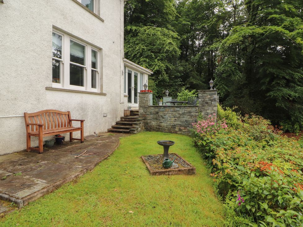 A garden with a stone wall and bench at High Cross in Keswick