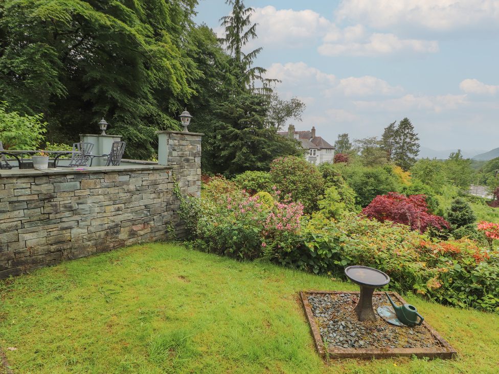 A garden with a stone wall and seating at High Cross in Keswick