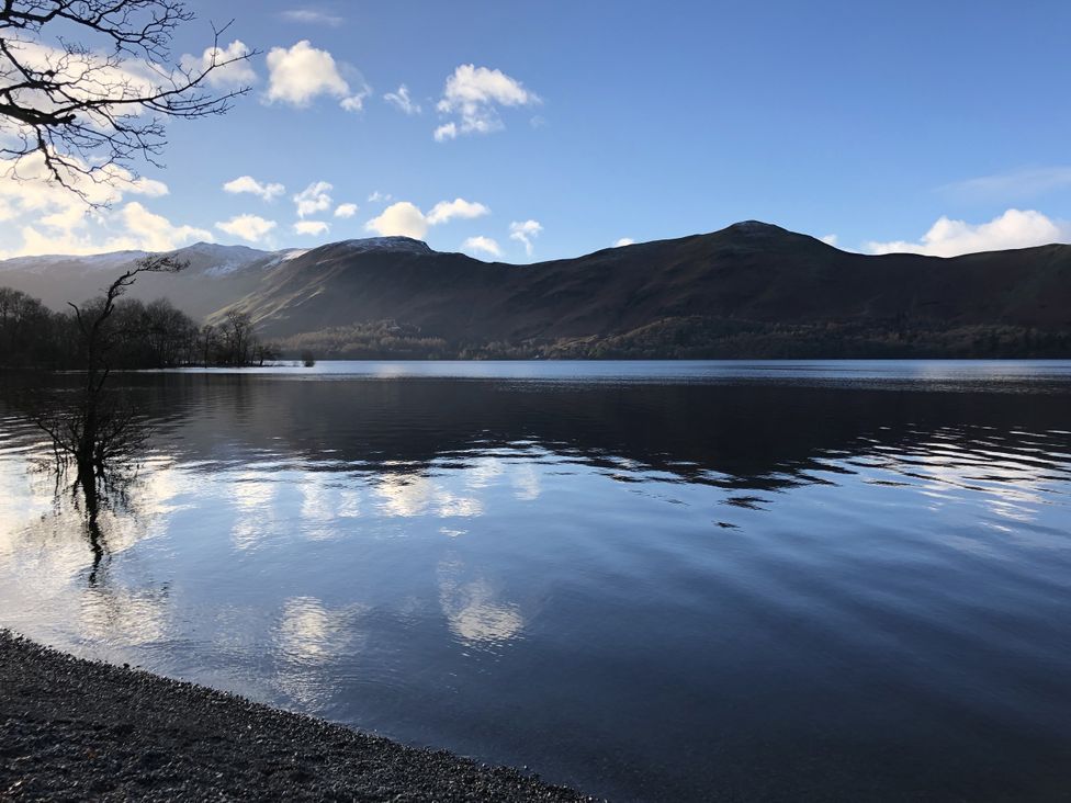 A lake with mountains and trees at High Cross in Keswick