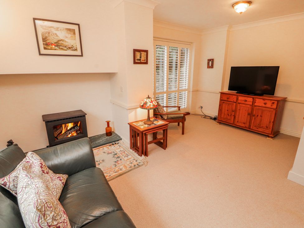 A living room with a fireplace and television at High Cross in Keswick