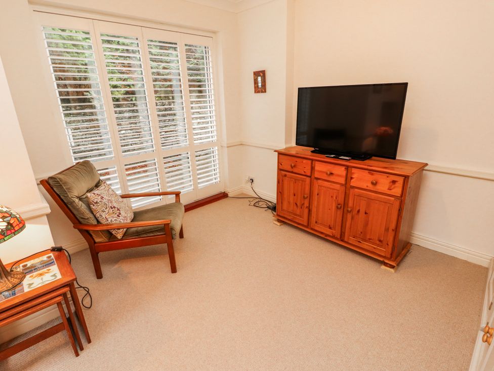 A living room with a television and an armchair at High Cross in Keswick