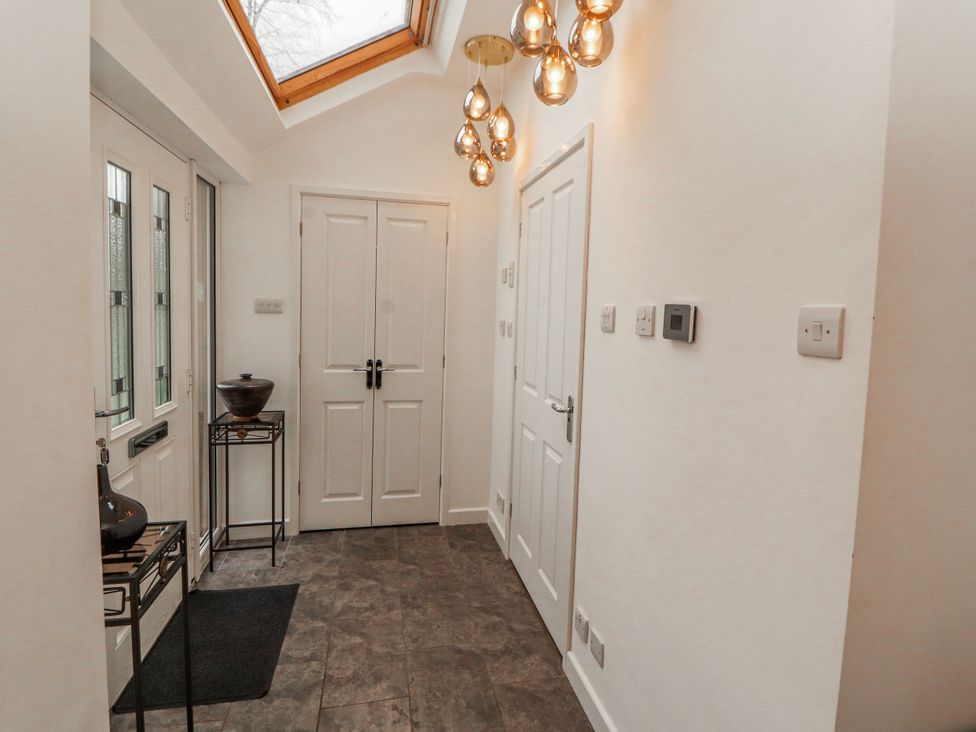 A hallway with a door and a light fixture at High Cross in Keswick