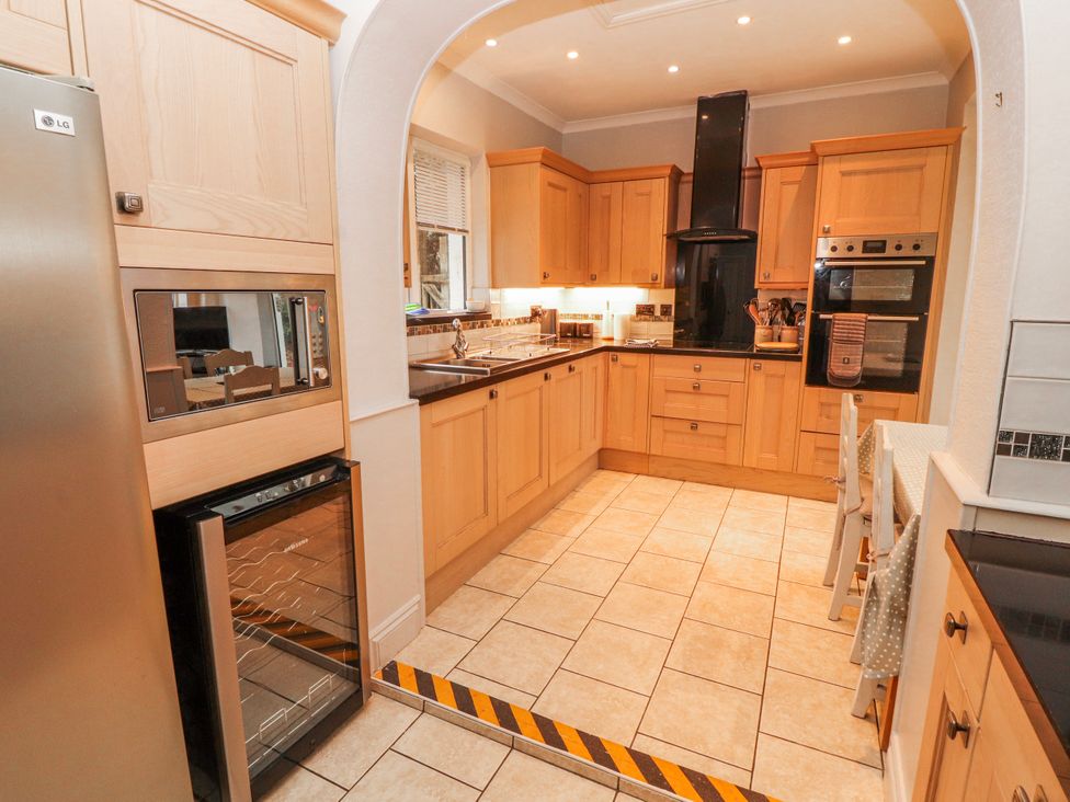 A kitchen with wooden cabinets and modern appliances at High Cross in Keswick
