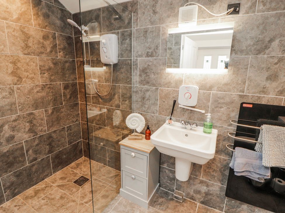 A bathroom with a shower and wash basin at High Cross in Keswick