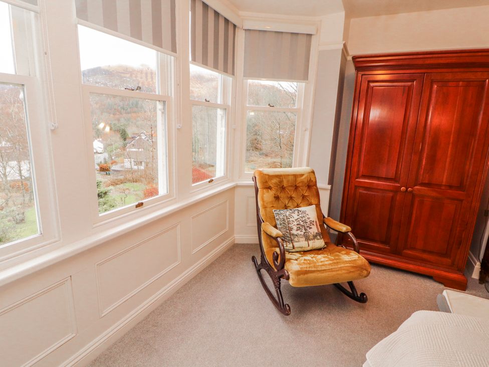 A bedroom with a rocking chair and wardrobe at High Cross in Keswick