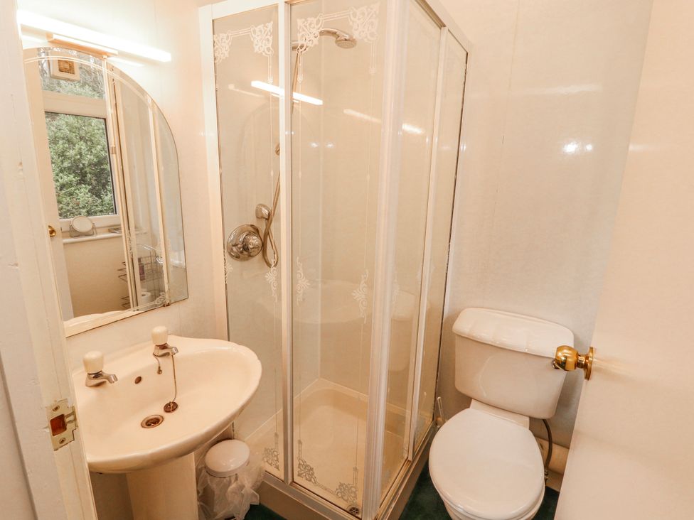 A bathroom with a shower, toilet, and sink at High Cross in Keswick